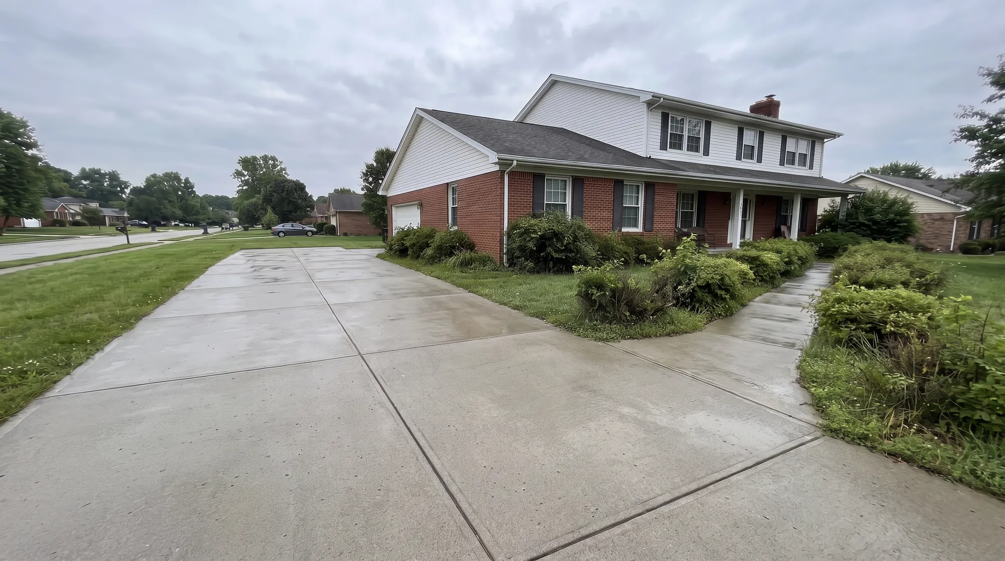 The same driveway and walkway after pressure washing, clean and bright