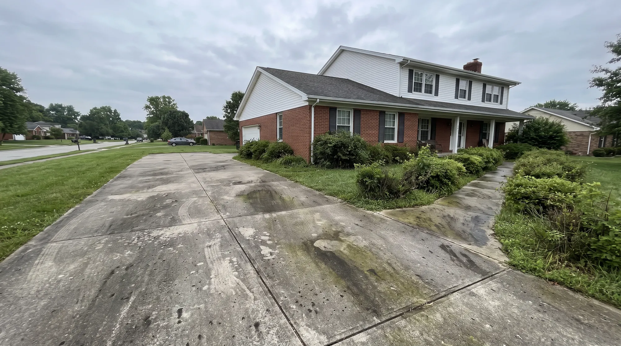 Concrete driveway and walkway covered in grime and mildew before pressure washing